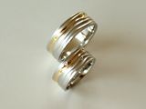 Eheringe aus Palladium 950 und Gelbgold 750 mit Wellen-Strukutr. Eine Welle ist aus Gelbgold 750 und wird somit betont. Im Damenring sind Brillanten eingearbeitet.
