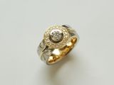 Schöner Schmuckring aus Weissgold und Gelbgold. Die Ringschiene ist strukturiert und im Ringkopf sind Brillanten gefasst.