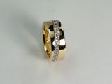 Polierter Ring aus Gelbgold 750. Die Diagonale aus Weissgold 750 ist ausgefasst mit Brillanten. Die Brillanten sind in Korn gefasst.