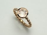 Kugeliring aus Rotgold 750. Im Ringkopf ist ein Rosenquarz gefasst.