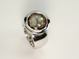 Markanter Schmuckring aus Silber 925 mit rundem Rauchquarz. Der Rauchquarz ist in einer Zarge gefasst. Der Ring ist hochglanzpoliert.
